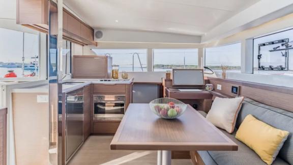 Stylish salon with dining area and panoramic windows on Lagoon catamaran, perfect for onboard comfort.