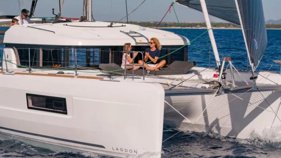 Enjoy sunny moments and fresh sea breeze on the deck of the Lagoon catamaran during a sailing trip.