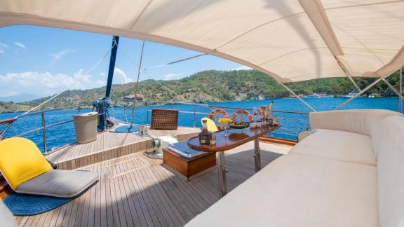 Comfortable sun deck of Gulet Cemre Mila with stunning views of the turquoise sea and surrounding landscape.