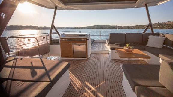 Der Lounge-Bereich auf dem Oberdeck des Katamarans Christal Mio bei Sonnenuntergang mit Blick aufs Meer.