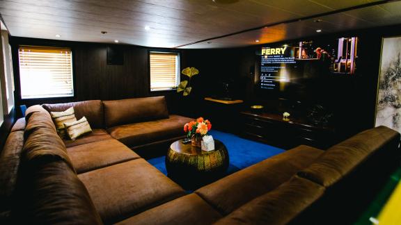 Das Kinozimmer der Motoryacht Harmony II bietet gemütliche Sofas und einen großen Fernseher.