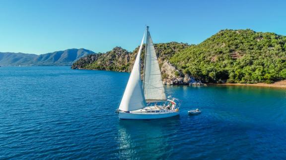 Die Segelyacht Conformista segelt in einer ruhigen Bucht auf blauen Gewässern.