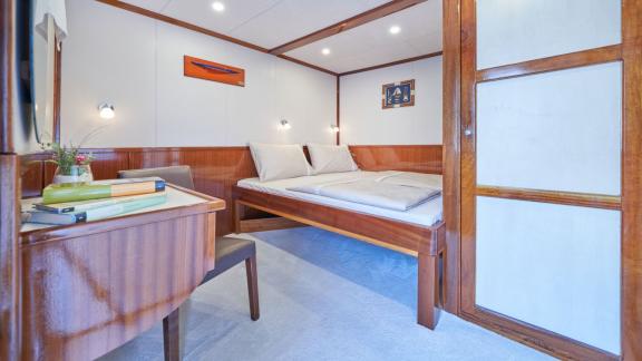 Geräumiges Schlafzimmer mit Doppelbett, Schreibtisch und maritimer Dekoration auf einer 9-Kabinen-Gulet aus Split.