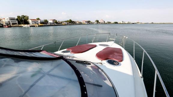 Auf dem Vorderdeck der Yacht Blondie befinden sich zwei rote Polster zum Sonnenbaden.