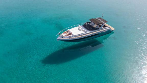 The Este motor yacht rests peacefully at anchor in the turquoise waters of Mykonos.