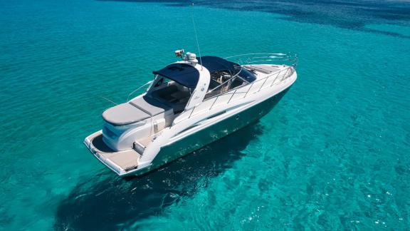 Seiten- und Heckansicht der Motoryacht Com Tu vor der Küste Ibizas.