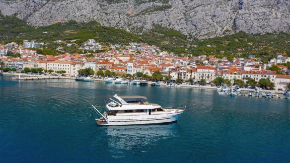 Motor yacht Custom Blanka on blue waters in front of a coastal town.