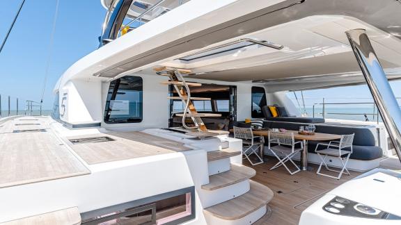 Luxurious outdoor area on the Catamaran Daiquiri featuring a comfortable dining space and access to the flybridge via an