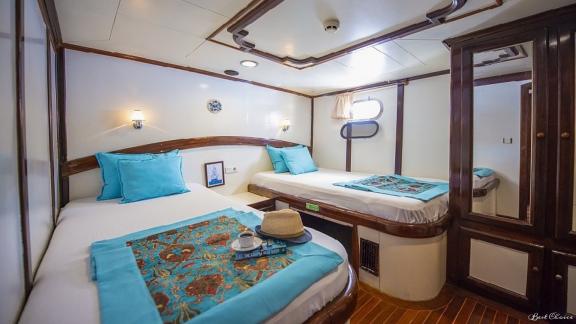 Double cabin of the gulet Vesta 1 Sevil with two single beds, maritime decoration and practical storage space.