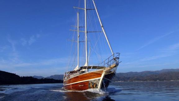 The gulet Dear Lila sails through the calm waters of Fethiye under clear skies.