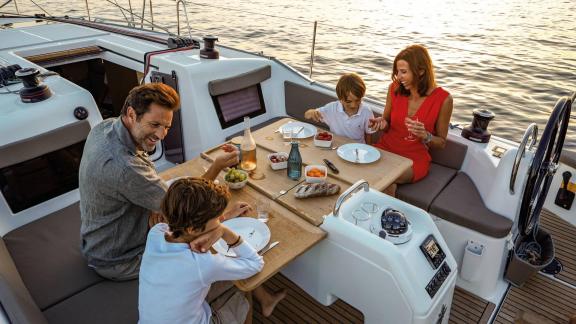 Eine Familie genießt das Abendessen auf dem Achterdeck der Segelyacht Sirius II.