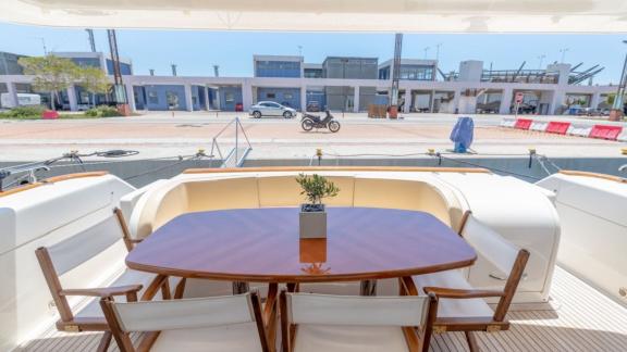 On the aft deck of the Venus Secrets yacht, there is a large table and comfortable seating.