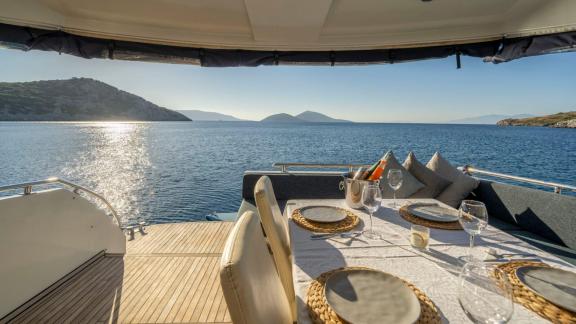 Dining area on the aft deck of motor yacht Moonlight with a sea view.