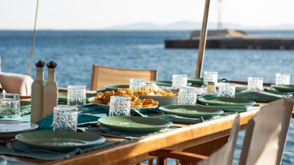 Eleganter Esstisch an Deck der Gulet Hera mit Blick auf das Meer und Hafen.