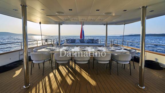 Eleganter Essbereich an Deck der Dalmatino-Yacht, ideal für Mahlzeiten mit Meerblick bei Sonnenuntergang.