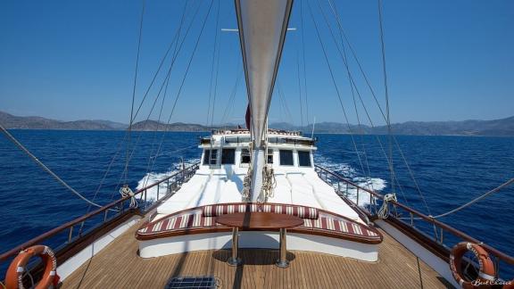 Deck der Gulet Vesta 1 Sevil auf offenem Meer, mit Blick auf die umliegenden Berge.