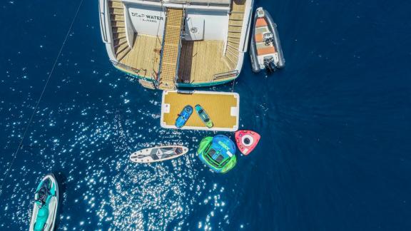 Motoryacht Deep Water mit Paddleboard, Schlauchbooten und Jet-Ski im klaren blauen Wasser von Marmaris.