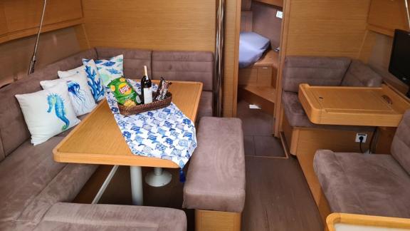 The interior salon of sailing yacht Desiree II, featuring a cozy seating area and stylish decor.