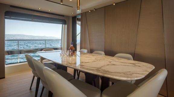 Stylish dining area on the motor yacht Volante with a stunning sea view.