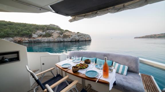 Eleganter Esstisch mit Meerblick auf dem Achterdeck der Motoryacht Never Give Up.