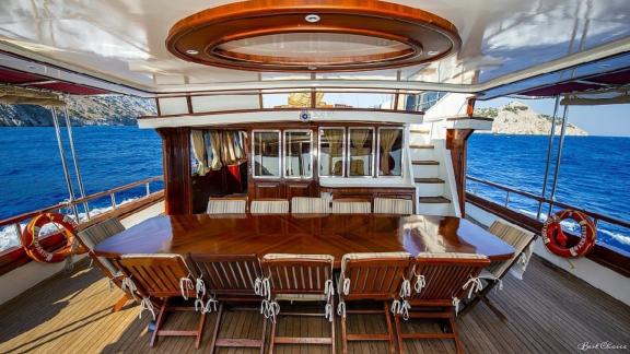 Elegant dining area on the deck of the gulet Vesta 1 Sevil, surrounded by sea views and comfortable seating.