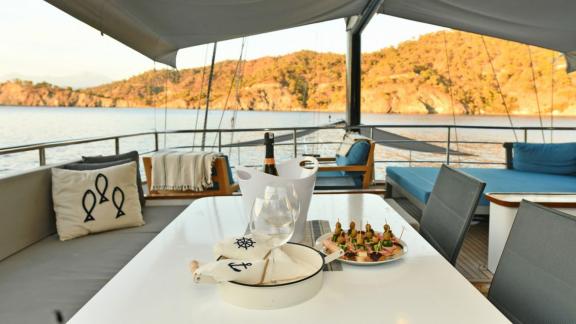 Enjoy a stylish dinner on Gulet Nayk 2 with stunning coastal views.