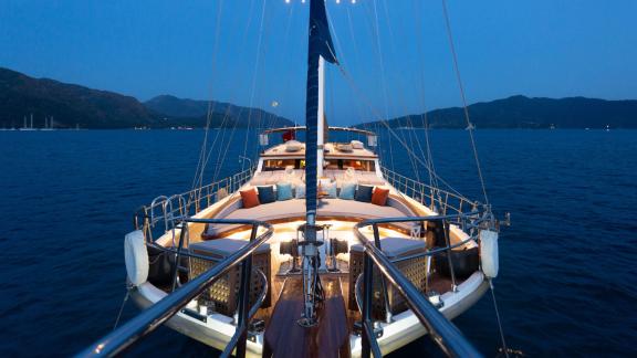 Gulet Diva Deniz with 6 cabins, illuminated deck at night.