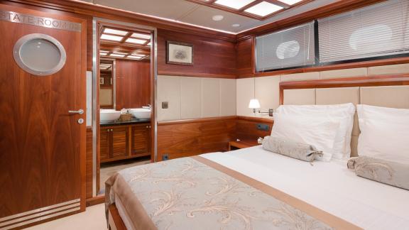 Роскошная спальня с двуспальной кроватью и отдельной ванной на яхте Lady Gita.