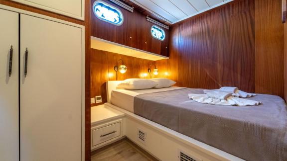 Каюта гулета ÇağAy оснащена уютной двуспальной кроватью, стильным освещением и практичными шкафами.