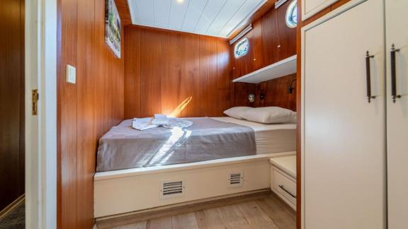 The bright cabin of Gulet ÇağAy offers a comfortable double bed and storage, perfect for restful nights.