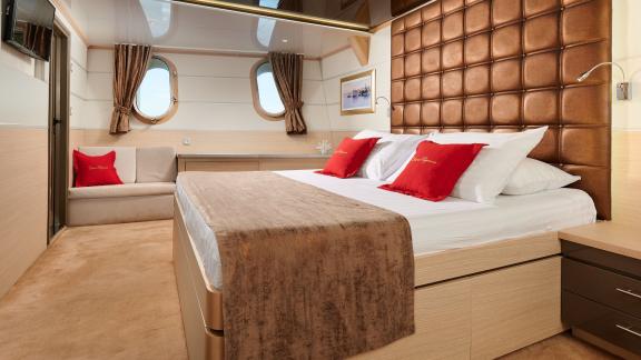 Elegant suite with a large double bed and seating area on the motor yacht Queen Eleganza