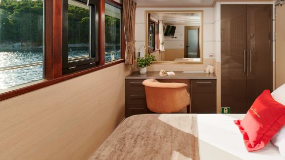 Stylish cabin with desk and sea view on the motor yacht Queen Eleganza