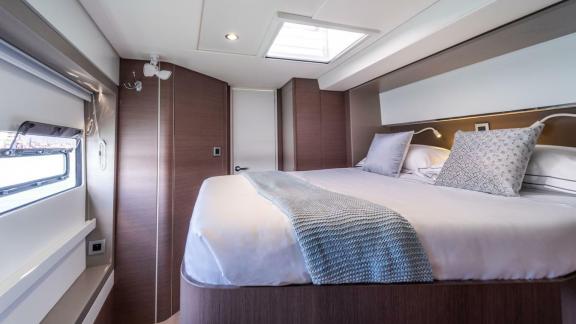 The elegant bedroom on the Bali 5.4 catamaran in Italy offers panoramic windows and stylish comfort for restful nights.