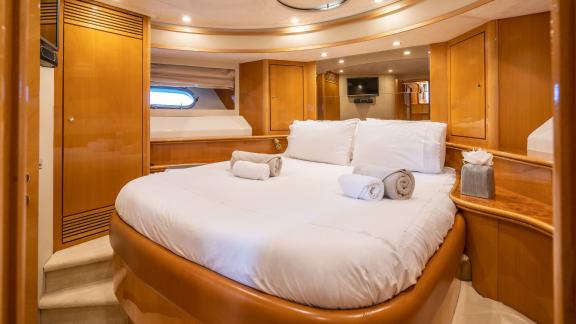 Das geräumige Schlafzimmer der Motoryacht Lady L zeigt ein großes Bett und elegante Holzmöbel.