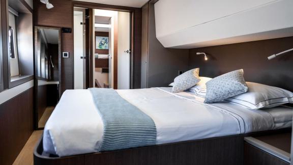The elegant bedroom with an ensuite bathroom on the Bali 5.4 catamaran in Italy offers maximum comfort and privacy.