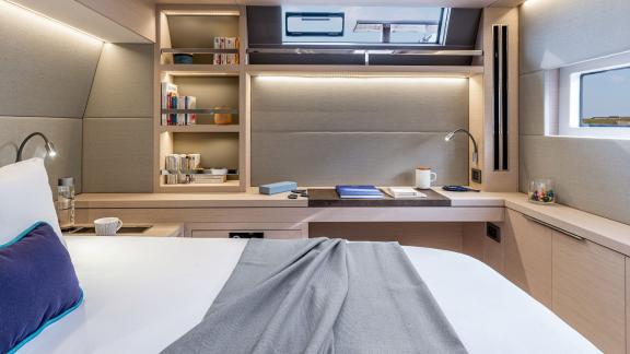 The modern yacht cabin features stylish bookshelves, a spacious desk, and a large bed for ultimate comfort.