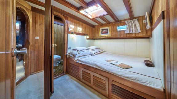 Cosy bedroom on a gulet with double bed, skylight and en-suite bathroom.