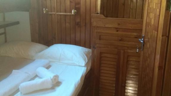 The bedroom on Gulet Aurora with wooden elements offers a cozy atmosphere.