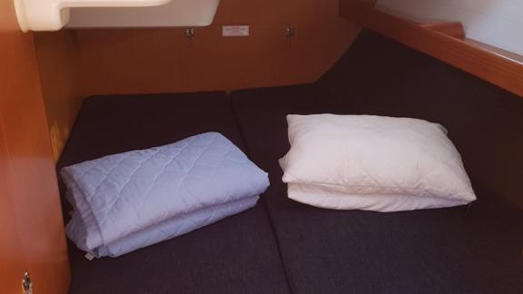 In der Doppelkabine mit Doppelbett der Segelyacht Vivi ist ein ordentlich arrangiertes Bett mit Kissen und Decken zu seh
