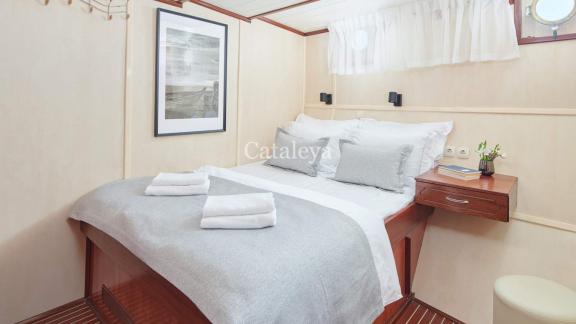 A stylishly furnished cabin with a cosy double bed, modern decor and natural light on the Gulet Cataleya in Croatia.