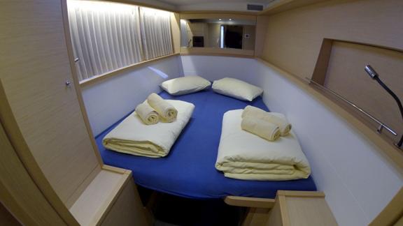 Cozy double cabin in the Saelma Lagoon 450 with a mirror and soft bedding, perfect for relaxation.