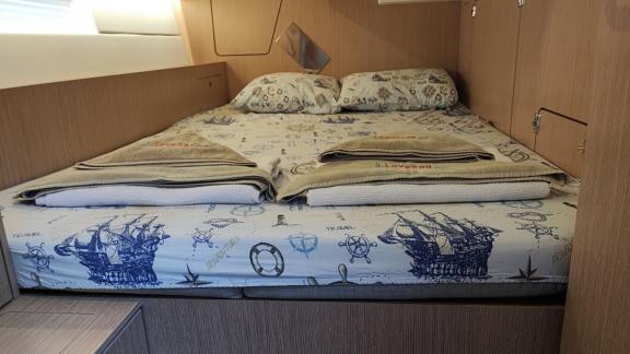 Third double cabin on the sailing yacht Blue Monkey with maritime-themed bedding and a large bed.