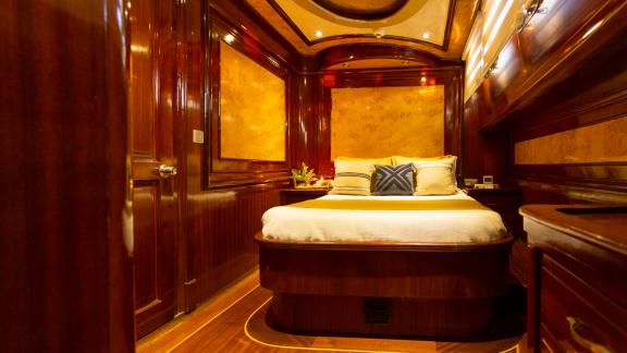 A comfortable cabin with elegant wood paneling and a large, cozy bed.