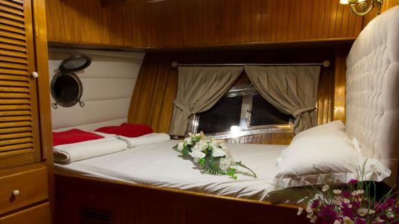 Stylish cabin with romantic decoration and large window on board the Gulet Hera.