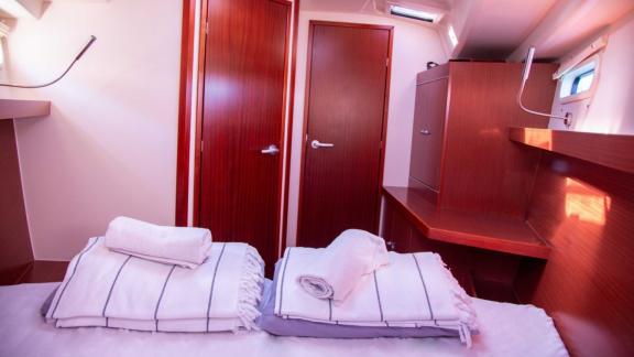 The double cabin on the Beau Gosse sailing yacht features an en-suite bathroom and storage space.