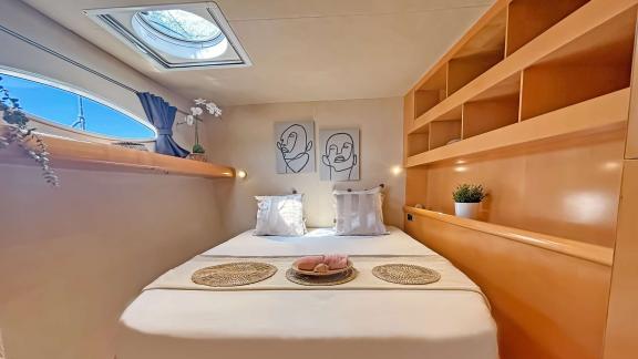 Cozy guest cabin on catamaran Zorba with a large window and stylish details for restful nights.