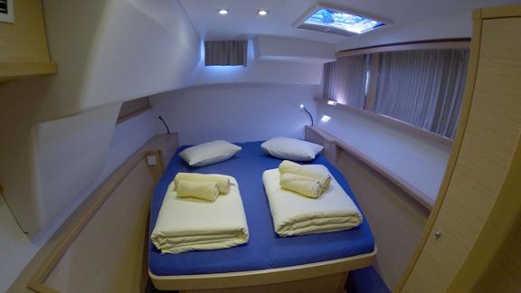 Bright double cabin with skylight and bedding in the Saelma Lagoon 450, perfect for restful nights.