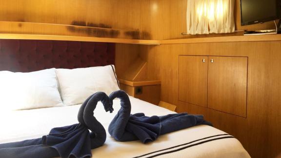 The cabin of the trawler yacht Atıl in Göcek features a comfortable bed and decorative details.