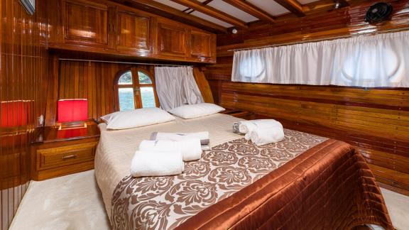 The double cabin of gulet Croatia offers a warm atmosphere with wooden details and a comfortable bed.