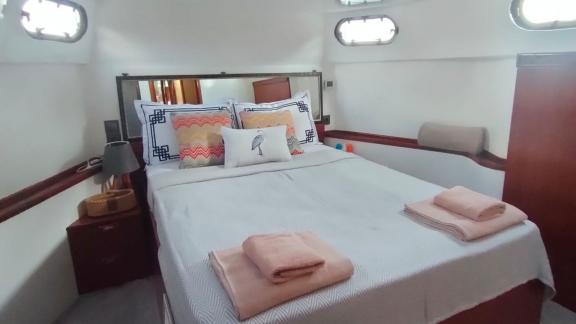 Comfortable double guest cabin on motor yacht Grida, with towels on the bed.